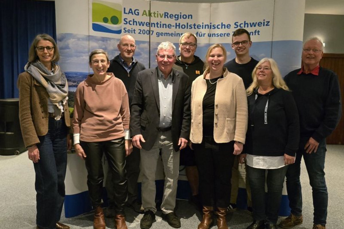 Acht Personen stehen vor einem Banner mit der Aufschrift 'LAG AktivRegion Schwentine-Holsteinsche Schweiz Seit 2007 gemeinsam für unsere Zukunft'
