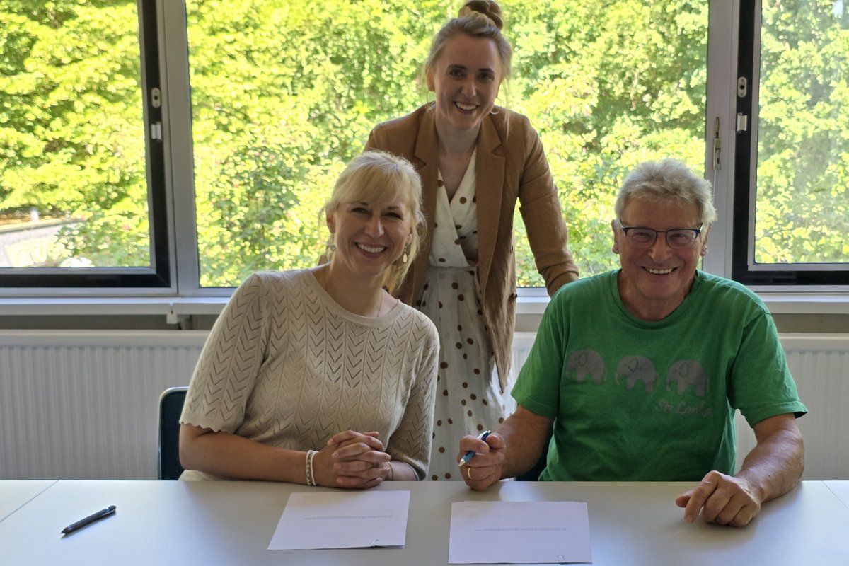 3 Menschen bei der Vertragsunterzeichnung